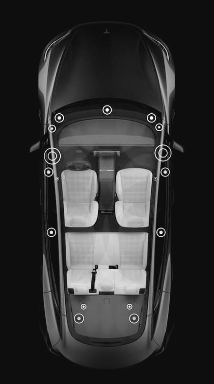 Model 3 vue de dessus, rendu Tesla en monochrome : les haut-parleurs cerclés de l'habitacle, le bloc sous le capot, la ligne d'échappement jusqu'à la sortie arrière, et toi au volant.